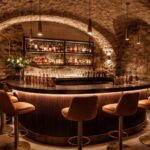 découvrez la transformation de la cave à vin lanrezac en un bar à cocktails élégant, alliant murs en pierre naturelle et éclairage design flos pour une ambiance chaleureuse et contemporaine.